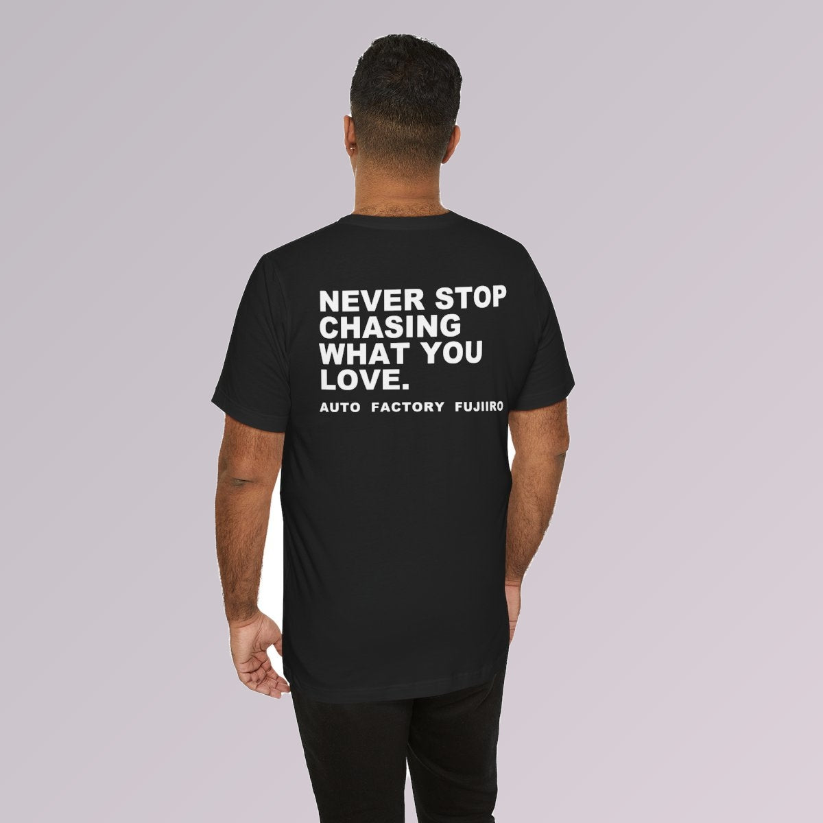 Black — NEVER STOP CHASING WHAT YOU LOVE printed across the back, worn