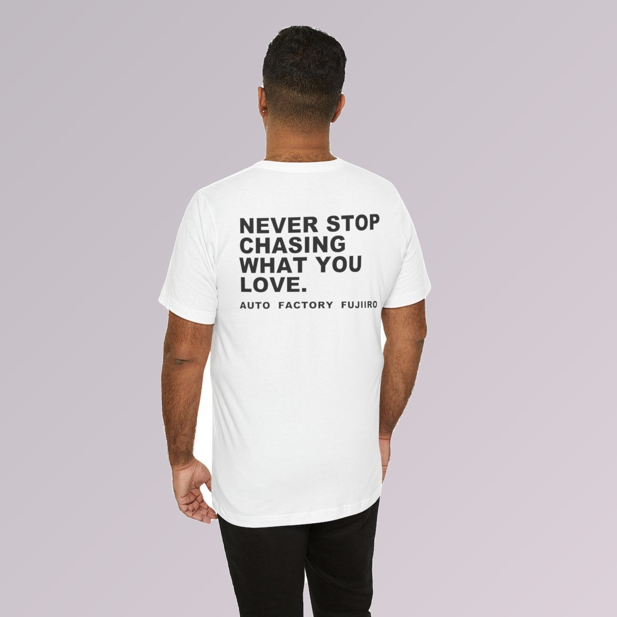White — NEVER STOP CHASING WHAT YOU LOVE printed across the back, worn