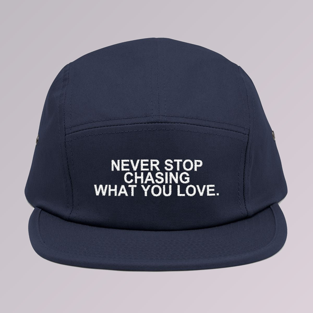 Navy — NEVER STOP CHASING WHAT YOU LOVE five-panel cap, front view, slogan embroidered across the front panel