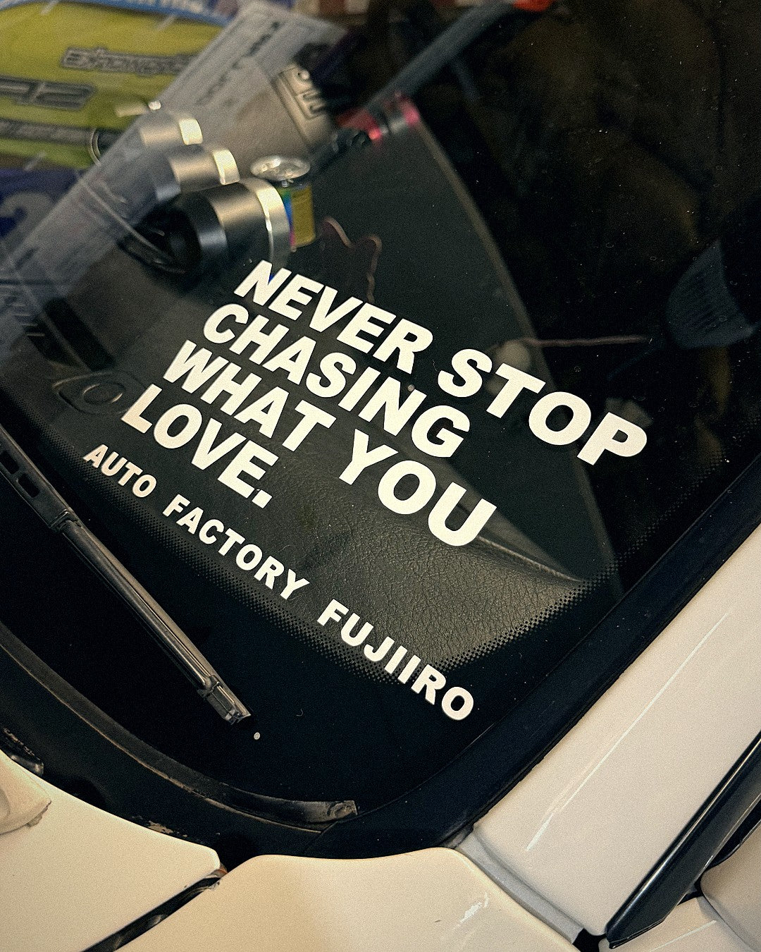 NEVER STOP CHASING WHAT YOU LOVE decal on the windshield of a white S-chassis